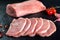 Fresh and raw meat. Pork tenderloin, loin medallions steaks in a row ready to cook. Background black blackboard