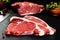 Fresh and raw meat. Ribeye. Uncooked steaks on black background blackboard