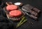 Fresh raw minced homemade farmers grill beef burgers on vintage chopping board with spices and herbs and meat hatchet, fork and
