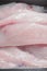 Fresh raw monk fish fillet close up on a black plastic tray Retail industry product. Fishmonger craft . Premium price cut. Pink