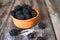 Fresh raw organic blackberries in a clay bowl on old wooden table