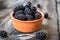 Fresh raw organic blackberries in a clay bowl on old wooden table