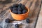 Fresh raw organic blackberries in a clay bowl on old wooden table