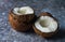 Fresh raw organic coconut fruits ripe in halfs over dark stone background