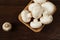 Fresh raw porcini boletus mushrooms in square bamboo bowl