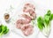 Fresh raw pork chops with spices and thyme and cabbage Bok Choi on light background, top view