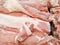 Fresh raw pork meat in refrigerated counter in supermarket. Fresh pink raw pork cut into pieces by butcher & sell at meat product