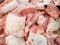 Fresh raw pork meat in refrigerated counter in supermarket. Fresh pink raw pork cut into pieces by butcher & sell at meat product