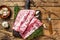 Fresh raw pork rack spareribs with thyme and garlic on cutting board. wooden background. Top view