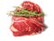 Fresh raw rib eye steak with green rosemary leafs on white isolated surface. Meat industry product. Premium tender meat cut