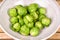 Fresh raw rustic brussels sprouts in a ceramic bowl