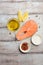 Fresh raw salmon steak with lemon, olive oil and spices on rustic wooden background. Ingredients for making healthy dinner. Health