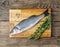 Fresh, raw, saltwater fish, sea bass on a wooden cutting board o