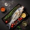 Fresh raw Sea bass fish with ingredients for making on a baking sheet. Top view. Generative AI