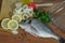 Fresh raw sea bass fish on wooden cutting board