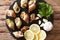Fresh raw shellfish whelk, sea snails bulot close-up and lemon,