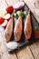 Fresh raw Triglidae, sea robins or gurnard fish with spices, vegetables and lemon closeup on a slate board. vertical