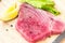 Fresh raw tuna fillet with black pepper corns, salt, lemon and olive oil on rustic background. Raw tuna steak on wooden cutboard,