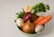 Fresh raw vegetables, carrot, onion, garlic, celery and parsley in a dish on a white background.