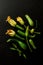 Fresh raw wet baby zucchini with flowers on black background