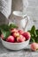 Fresh red apples in a white bowl and enameled pitcher