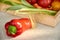 Fresh red bell pepper in the foreground in a sunshine on gray concrete surface close up. Vegetables on blurred background