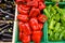 Fresh red bell pepper and green chilli in green plastic boxs, black violet eggplant fruit in wooden box, at the outdoor fresh