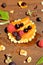 Fresh red, black raspberry and currant, peach, honey drop on waffle on wooden background close up