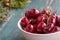 Fresh red cherries in a bowl, outdoors on a garden table