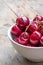 Fresh red cherries in a bowl, outdoors on a garden table