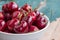 Fresh red cherries in a bowl, outdoors on a garden table