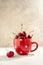 Fresh red cherries in a red mug. Summer, delicious seasonal fruits. Neutral background.