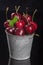 Fresh red Cherries in small metal bucket on black background, Close up, vertical composition - Image