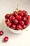 Fresh red cherries in white bowl, on neutral background. Summer delicious fruit.