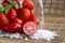 Fresh red cherry tomato and rock sea salt on rustic wooden background.