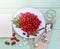 Fresh red cornel berries on white plate, preparing for homemade cornelian cherry jam, surrounded by jelly jar.