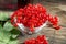 Fresh red currants in bowl ,syrup in a glass bottle on table