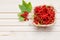 Fresh red currants in bowl on wooden table close up.Ripe large organic red currant in a wicker basket.Summer fresh