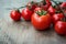 Fresh red delicious tomatoes on an old wooden tabletop backgro