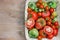 Fresh red and green tomatoes in a basket on a table