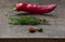 Fresh red pepper, sprig of rosemary, wooden spoon