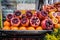Fresh red pomegranates, oranges and carrots sold on a market stall