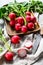 Fresh red radishes in a wooden bowl. Farm organic vegetables. Gray background. Top view