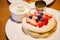 Fresh red strawberries and blackberries fruit toppings on pancake seasoned with whipped cream. Healthy sweets, desserts, snack,