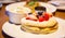 Fresh red strawberries and blackberries fruit toppings on pancake seasoned with whipped cream. Healthy sweets, desserts, snack,