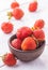 Fresh red strawberries with cream on the white wooden table.