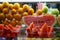 Fresh red watermelon fruit cut in tray with clear fork selling in local market with orange and green apple blurred background