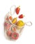 Fresh red and yellow paprika in reusable natural bag on white