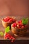 Fresh redcurrant in bowls over rustic wooden background