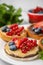 Fresh rice cake and rusks with different toppings served on white plate, closeup